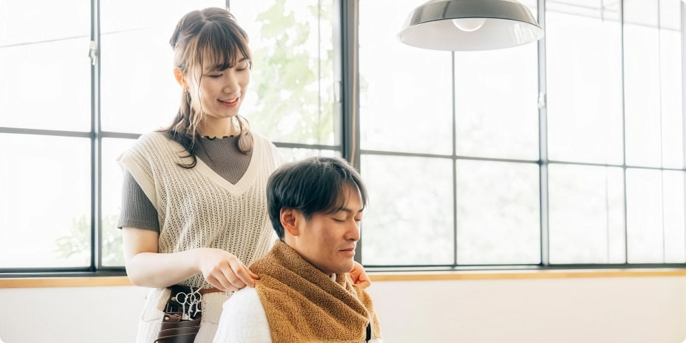 美容師がサロンでお客様にカウンセリングをしているイメージ