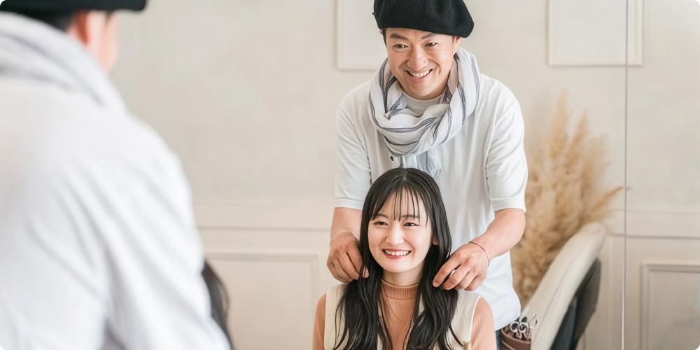美容室で笑顔で接客するスタイリストのイメージ