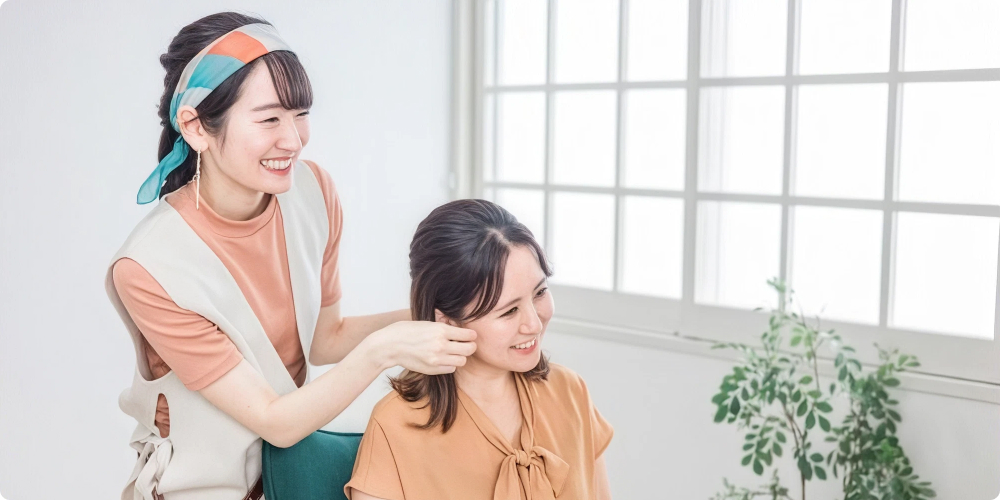 笑顔で接客するヘアスタイリストと満足そうなお客様のイメージ