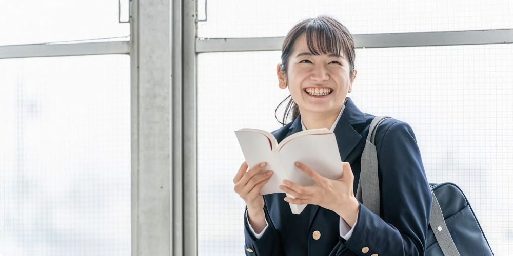 進路を考える高校生が明るい表情で資料を見ているイメージ