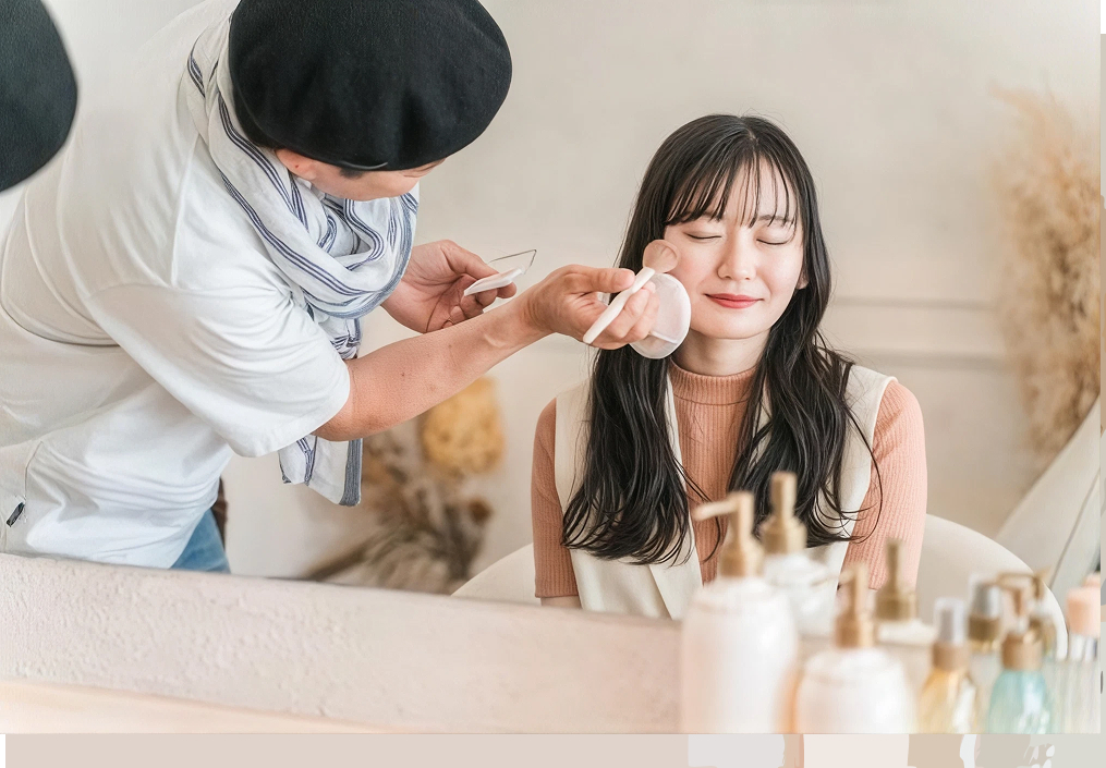 撮影現場でモデルにヘアメイクを施すアーティストのイメージ
